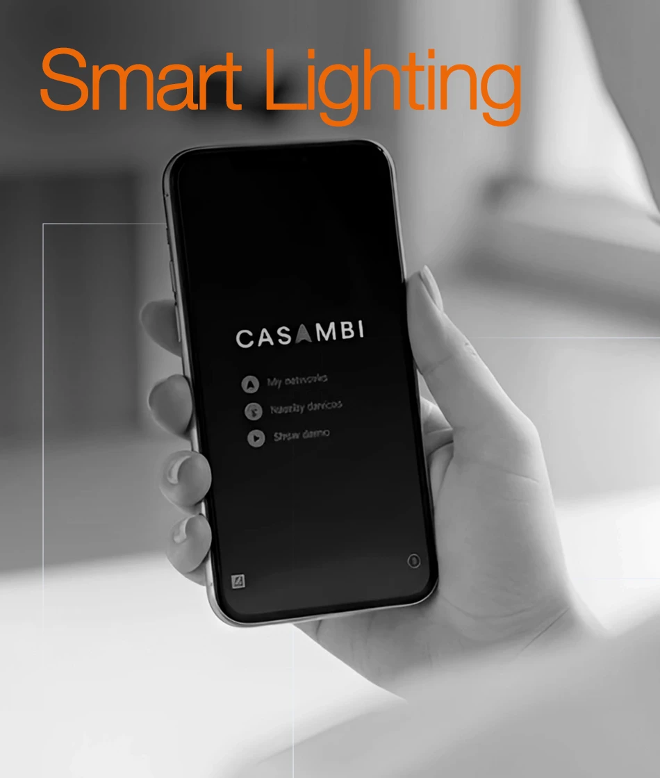 Hand holding a smartphone with Casambi smart lighting controls app on the screen.
